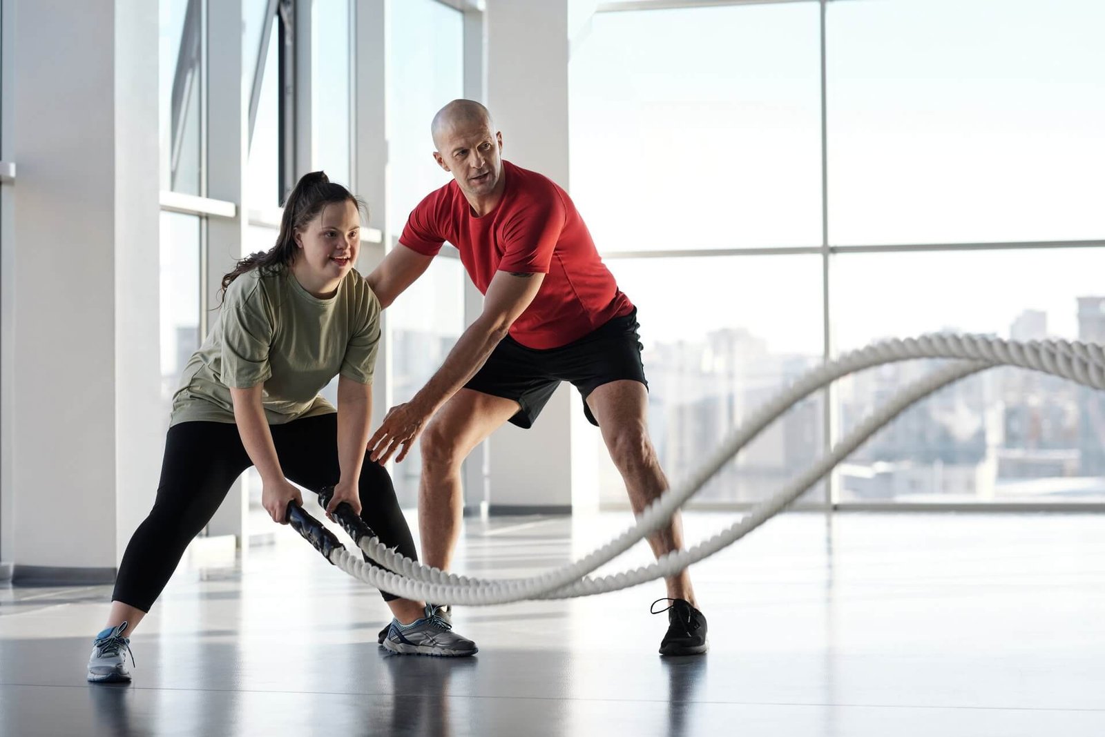 A Those Trainers coach guiding a member through a battle rope exercise in the studio