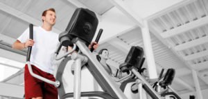 Member training on an elliptical machine in a residential fitness center